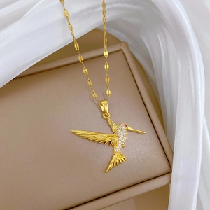 Titanium gold hummingbird pendant necklace with crystals on beige jewelry box display