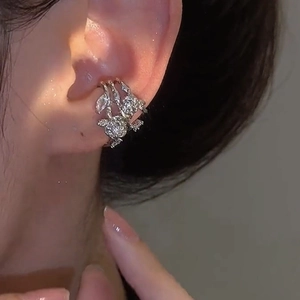 Detailed view of silver zircon flower ear cuff worn on the ear bone with shiny metal texture