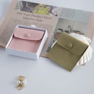 Detail of premium velvet jewelry pouches in pink and olive green with metal snap buttons