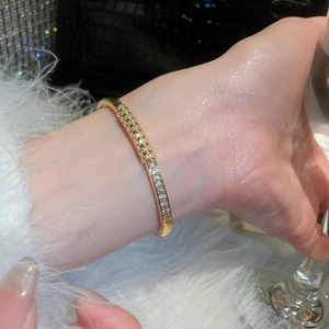 Detail of 18k gold plated bangle with sparkling cubic zirconia on model wrist