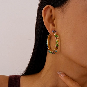 Macro detail of colorful beaded hoop earrings featuring rainbow faceted glass beads