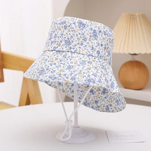 Detail of floral bucket hat with wide brim and adjustable drawstring on a wood chair