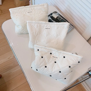 Three-piece set of white quilted cosmetic bags with lace, shell pattern, and black polka dots