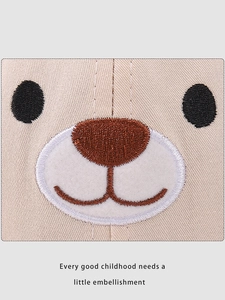 Detailed close-up of cute bear embroidery on beige canvas sun hat for children