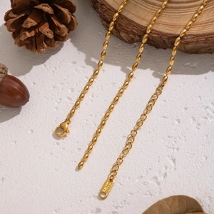 Collana a Y con perline ovali placcata oro 18K su sfondo naturale in legno e pigne