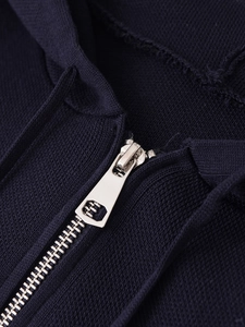 Close-up of a silver metal zipper on a dark blue knit hoodie with soft fabric texture