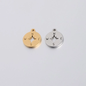 Close-up of gold and silver compass pendants with hollow star design in stainless steel