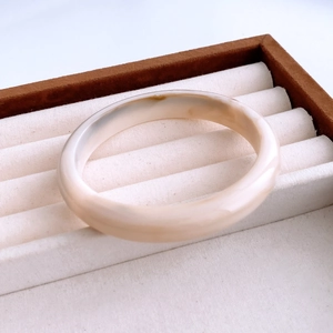 Close-up of minimalist creamy white acrylic marbled bangle in a velvet jewelry box
