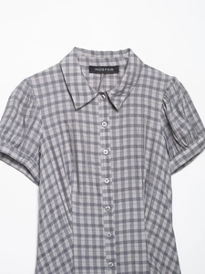 Close-up of the grey and white plaid pattern and textured fabric on the short sleeve dress