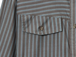 Détail d'une chemise marron à rayures bleues avec poche poitrine et fermeture à bouton
