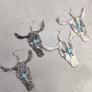 Detail of cattle head earrings with leopard fur texture, silver cactus and turquoise stone
