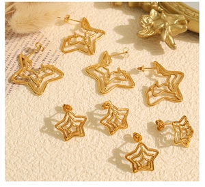 Detail shot of golden star-shaped earrings and hollow pentagram hoops with a vintage feel