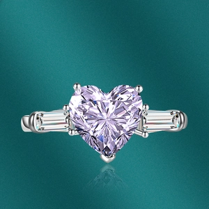 Macro detail of silver heart-shaped pink zircon ring with baguette side stones