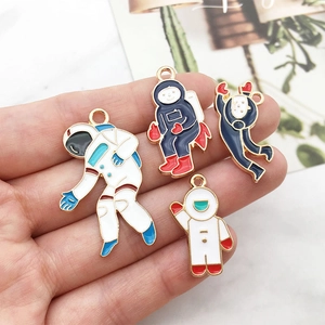 Handheld detail of colorful astronaut alloy charms with gold-plated edges for DIY crafts