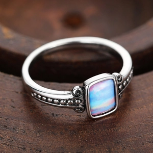 Macro shot of vintage teardrop ring with iridescent opal and oxidized bead details