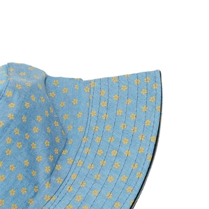 Detail of blue denim bucket hat with yellow floral print and reinforced stitching
