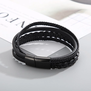 Detail of multi-layer black leather braid and polished magnetic clasp on men's bracelet