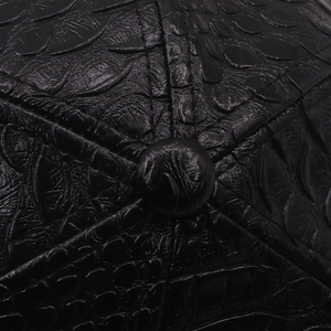 Vue macro détaillée de la texture crocodile noire et du bouton supérieur d'une casquette en cuir