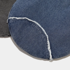 Detailed close-up of distressed denim beret featuring raw fringe edges and twill texture