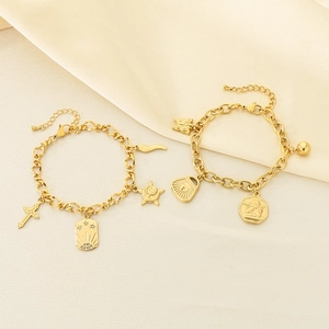 Gold layered chain bracelet set with cross and celestial charms on silk background
