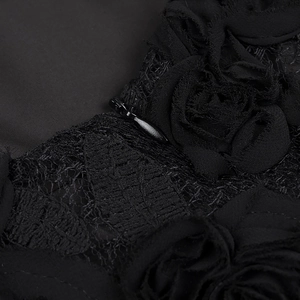 Detailed view of floral lace applique and invisible zipper on black pleated maxi dress