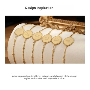 Detailed view of S925 sterling silver bracelets with engraved gold letter pendants