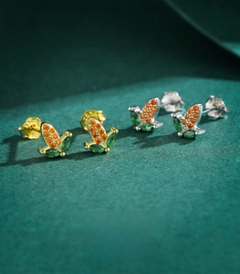 Macro detail of S925 sterling silver corn stud earrings with green and orange gems