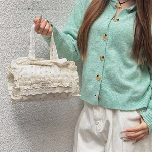 Détails d'un sac cabas en toile florale avec bords en dentelle multicouches et logo