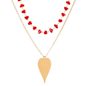 Détail du collier double rang avec perles rouges facettées et grand cœur doré