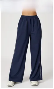 Détail du pantalon de jogging bleu marine à taille haute et bandes latérales blanches