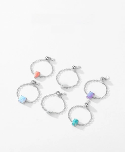 Flat lay of colorful opal chain rings in heart and geometric shapes on S925 silver