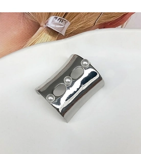 Detailed close-up of a U-shaped silver metal hair pin set with three elegant pearls