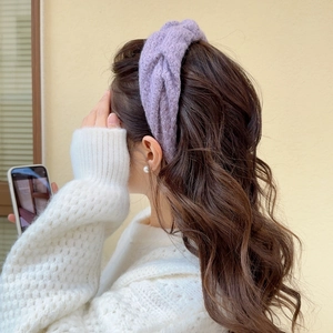 Detail of purple chunky knit twisted headband on model showcasing warm winter texture