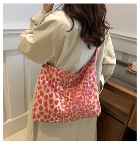 Leopard print canvas tote bag shown on model wearing a beige trench coat indoors