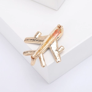 Detail of the golden airplane brooch back featuring a secure metal pin fastener