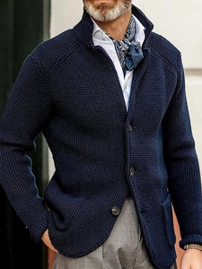 Close-up of navy blue knit cardigan with stand collar and dark brown button details