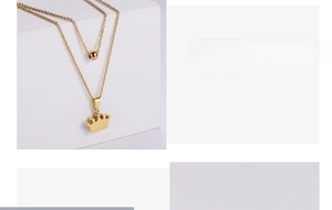 Detail of gold-plated double-layer necklace set with crown pendant and metal beads