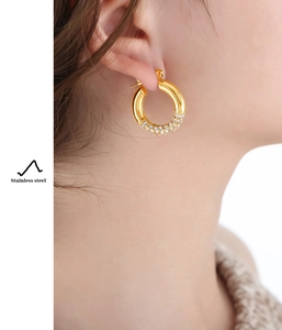 Close-up of gold-plated stainless steel hoop earrings with sparkling pavé crystals