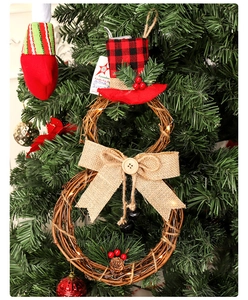 Detailed view of LED snowman rattan wreath with pine cones and red berries for Christmas