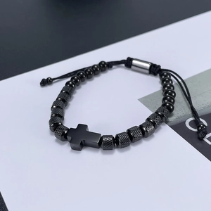 Macro shot of black stainless steel cross charm with beaded weave on adjustable bracelet