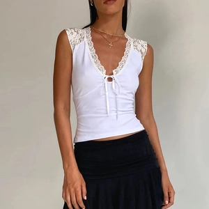 Detail of white slim fit tank top featuring delicate lace trim and ribbon bow on V-neckline