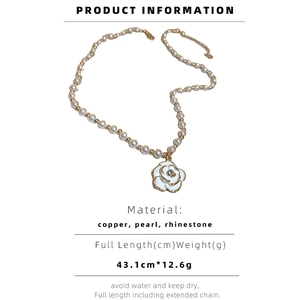 Detail of camellia flower pendant necklace with white pearls and small rhinestone inlay