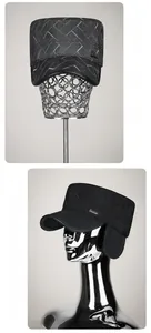 Detail of winter quilted flat top hat with ear flaps and metallic Vashion logo