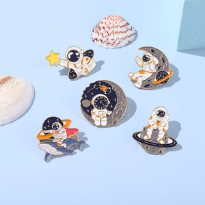Space enamel pins set featuring cute astronaut and whale motifs in orange and white