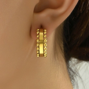 Elegant gold hoop earrings featuring bead chain detail on ear for a stylish french look