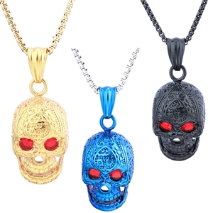Detailed view of skull pendants in gold, blue, and black with red gemstone eyes