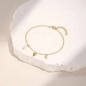 Detailed top view of gold S925 silver bracelet with heart, moon pendants and pearl on stone