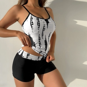 Detail of high waist tankini swimsuit with tie-dye print and black boyshort bottoms