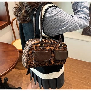 Detail of leopard print shoulder bag with patent leather trim and golden hardware