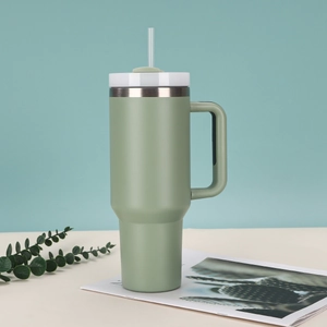 Detail of a 40oz green insulated stainless steel tumbler with handle and clear straw